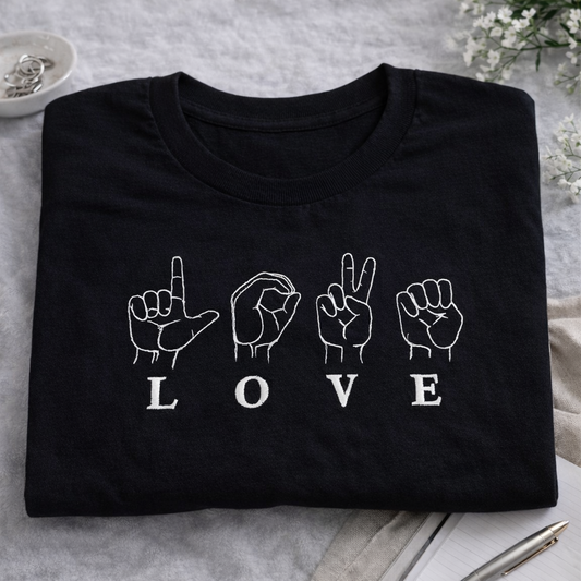 LOVE SIGNS Embroidered Tee featuring minimalist hand-sign design on a black heavyweight cotton fabric.